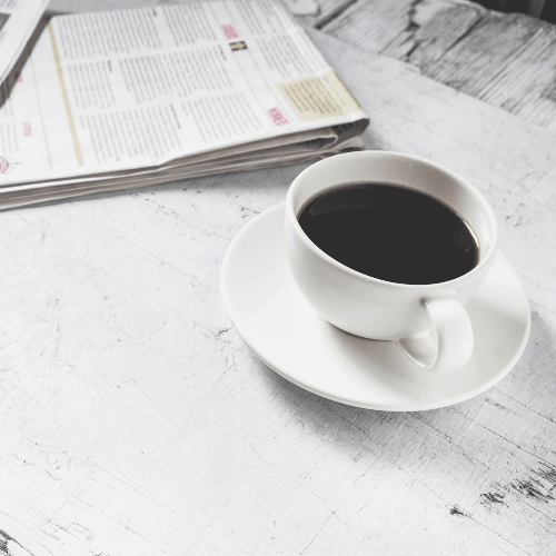 Coffee cup and morning newspaper