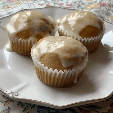 orange marmalade muffins with cream cheese glaze on white china plate
