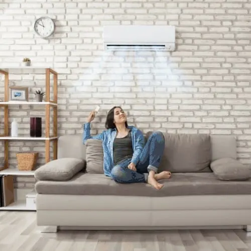 woman relaxing under PTAC in home