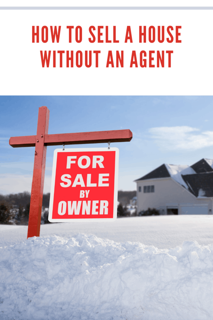 For Sale by owner real estate sign in front of large brick single family house in expansive snow covered yard in mid winter.