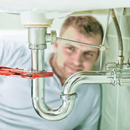 Photo of plumber repairing drain.