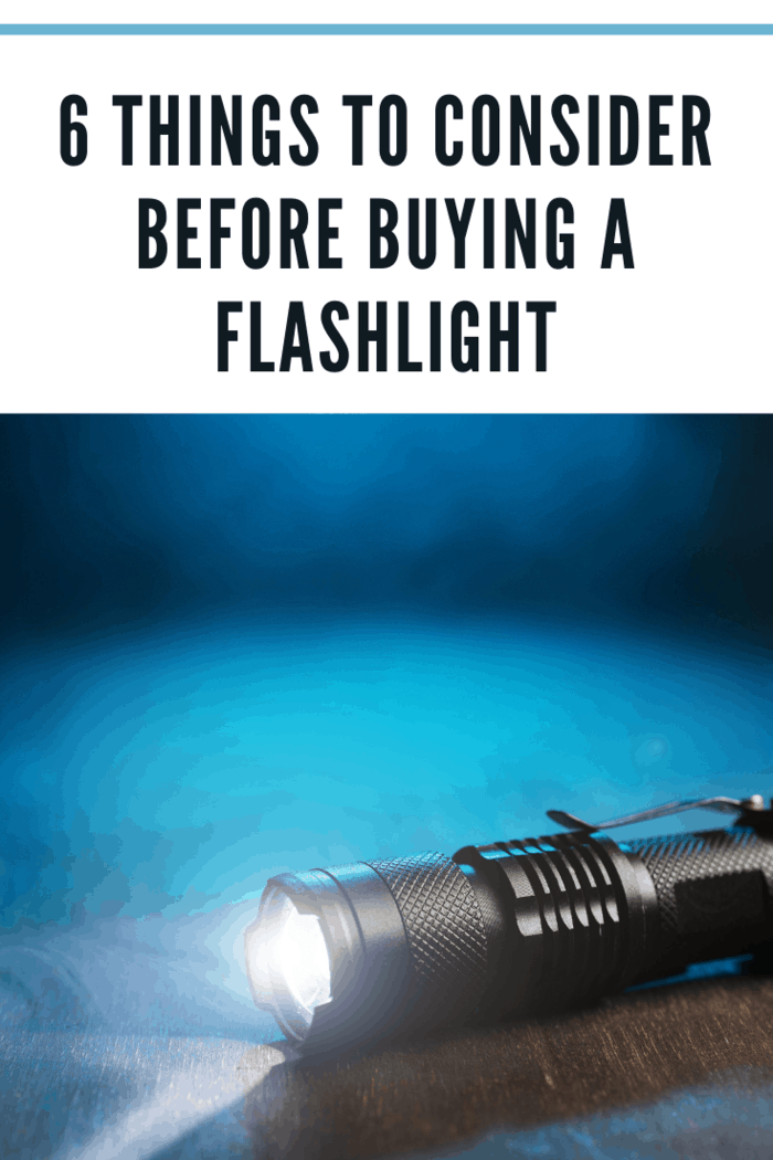 Tactical waterproof flashlight. LED flashlight shines on the table in smoke.