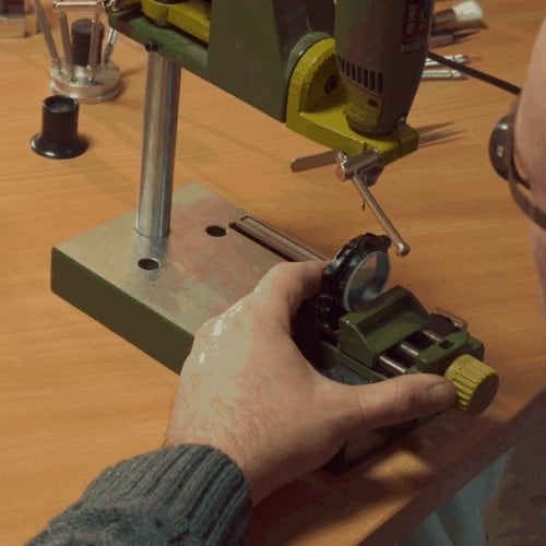 hands using a drill press in jewelry making