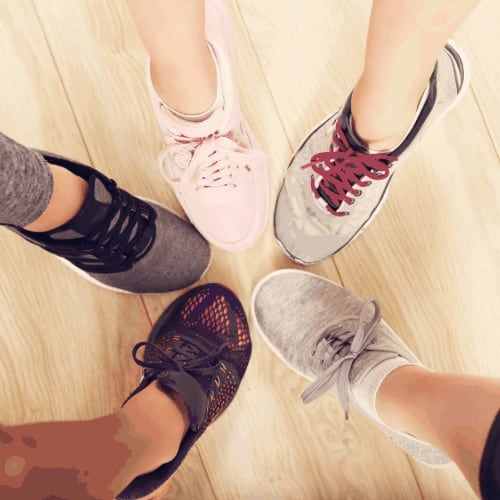 Circle of female legs with shoes in a gym