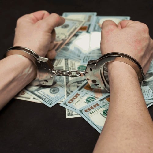 Man in handcuffs with money and drugs on dark background. The concept of punishment for possession, distribution and use of drugs. Concept legal consequences of drug possession.
