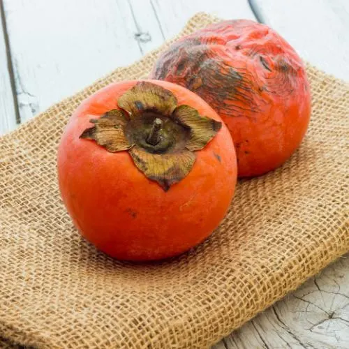 Fresh persimmons on burlap showcasing their health benefits and vibrant color