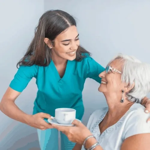 Pretty helpful care talking with female patient. Health visitor and a senior woman during nursing home visit. Supportive senior care assistant and smiling older woman in nursing home