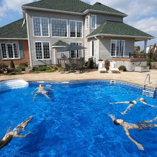 Family floating in backyard pool