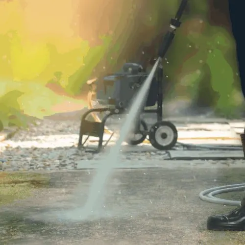 Man cleaning dirty walkway with high pressure water cleaner ,professional cleaning services concept.