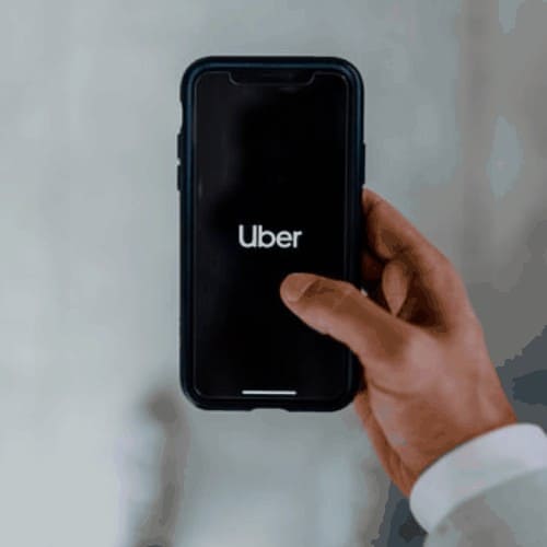 smartphone in hand with UBER on screen