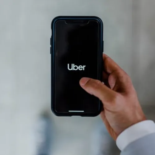 smartphone in hand with UBER on screen