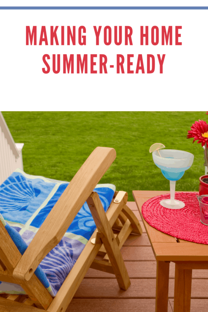 summer home scene, an outdoor deck or patio with wooden recliner and table, green grass in the background