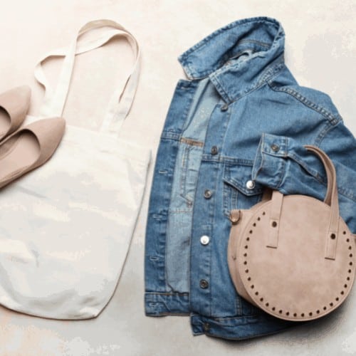 Fashionable women's denim jacket, shoes and bags on neutral background. Top view.