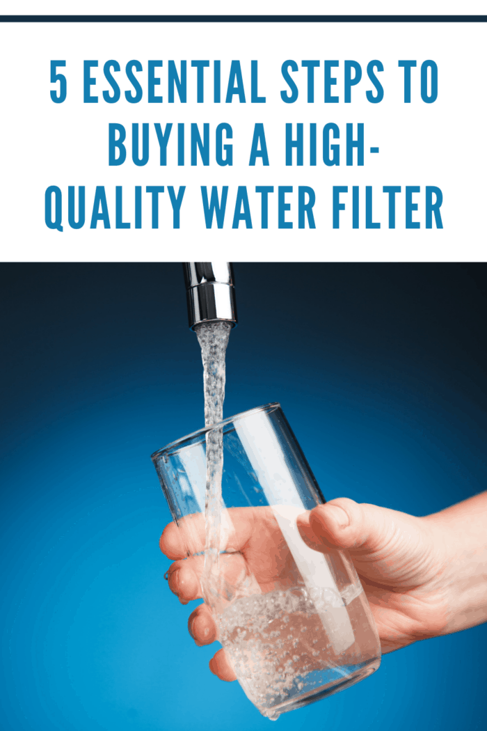 hand pouring a glass of water from water filter tap, blue background