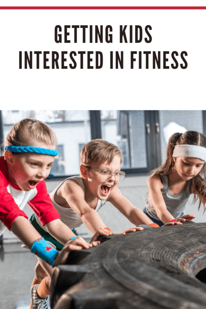 adorable kids in sportswear training with tire at fitness studio, children sport concept