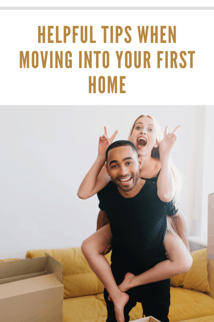 Very happy couple celebrating first day in new home, finishing packing, unpacking boxes, having fun in new apartment. Young man lifting woman on his back in room with yellow sofa.