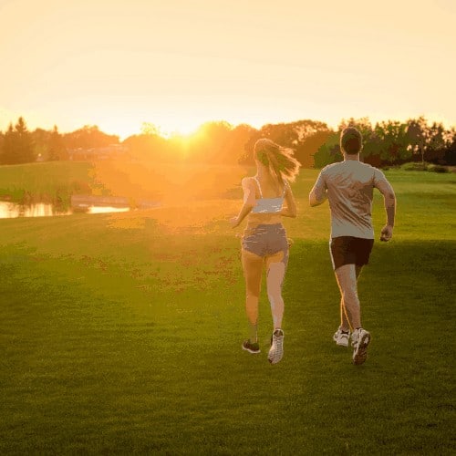 Guy and girl run through the beautiful nature reserve. Healthy lifestyle. Athletics. Evening jogging outdoors.