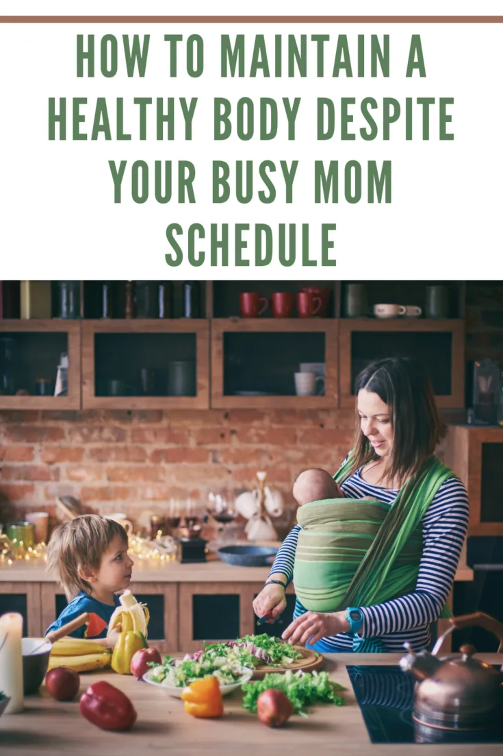 mom with newborn in momwrap on chest making a salad with toddler.