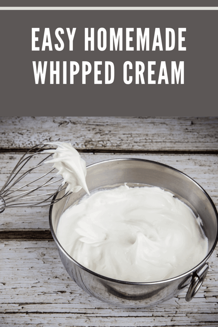 whipped cream in metal bowl with metal whisk.