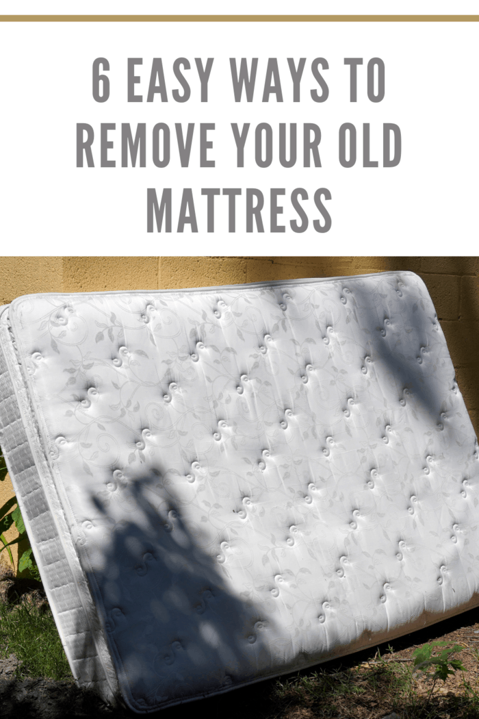 Old mattress leaning against a brown cinder block wall in an alley, illustrating urban mattress disposal