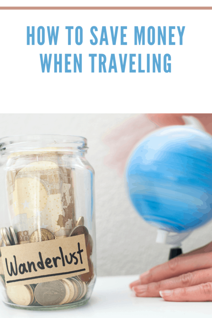 Saving up money to travel concept / Money jar with wanderlust note and rolling world map globe.