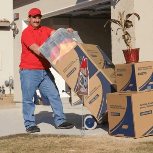 Delivery man holding cart with stack of containers