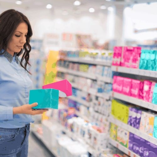 Woman choosing tampons in supermarket