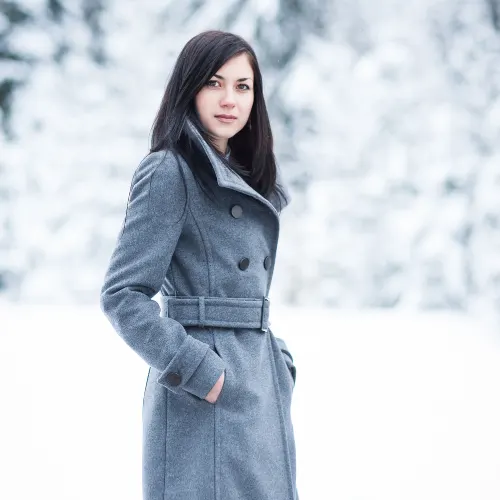A beautiful young woman in a grey jacket in the winter.