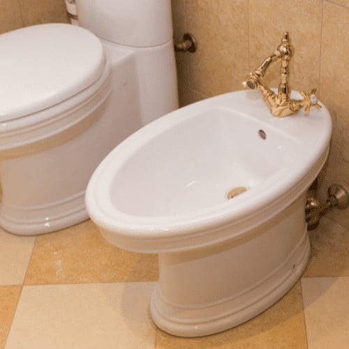 Beautiful bidet with gold tap in luxurious bathroom