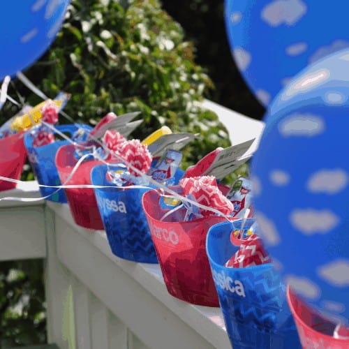 Large tubs of party favors and balloons for birthday party guests.