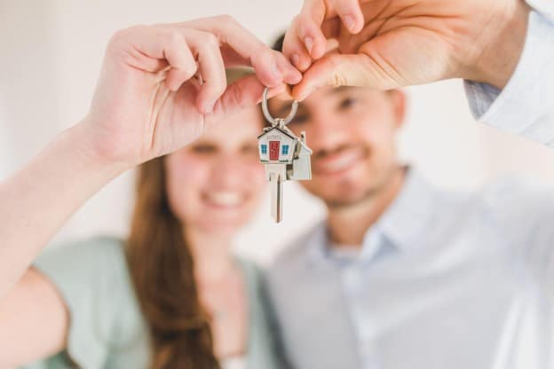 couple holding keys to new home