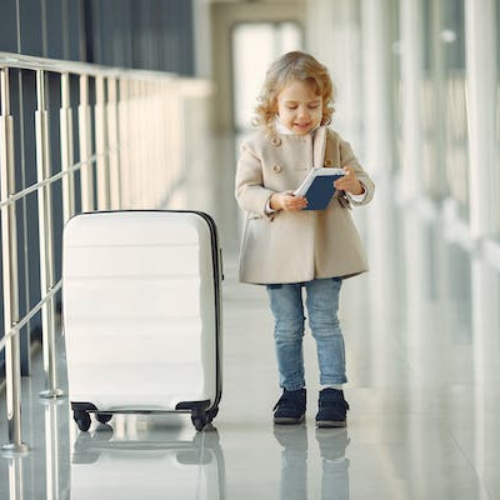 little girl at airport next to luggage