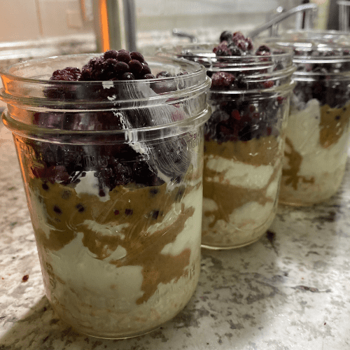 frozen berries, peanut butter, milk, and oats in mason jar