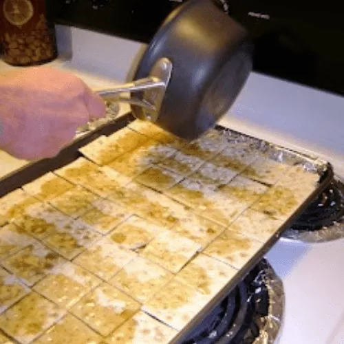 pouring toffee mixture over saltines