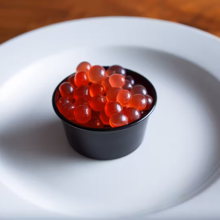 Boba pearls made with fruit juice in a clear glass, showcasing vibrant colors and chewy texture