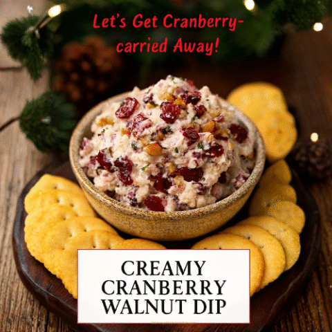 Close-up of creamy cranberry walnut dip in a rustic bowl surrounded by crackers and festive holiday decor. Garnished with cranberries and walnuts, the dip is styled on a wooden board with pine sprigs and fairy lights in the background.