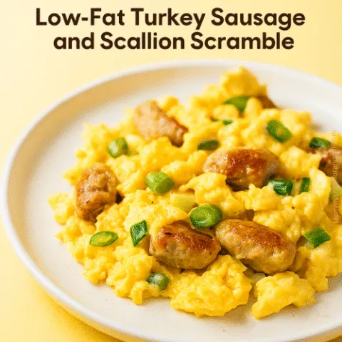 Close-up of Low-Fat Turkey Sausage and Scallion Scramble on a plate with bright natural light and yellow background, styled for a cheerful breakfast vibe with overlay text: &ldquo;The scramble that&rsquo;s worth waking up for, no yolk.&rdquo; and &ldquo;Low-Fat Turkey Sausage and Scallion Scramble.&rdquo;