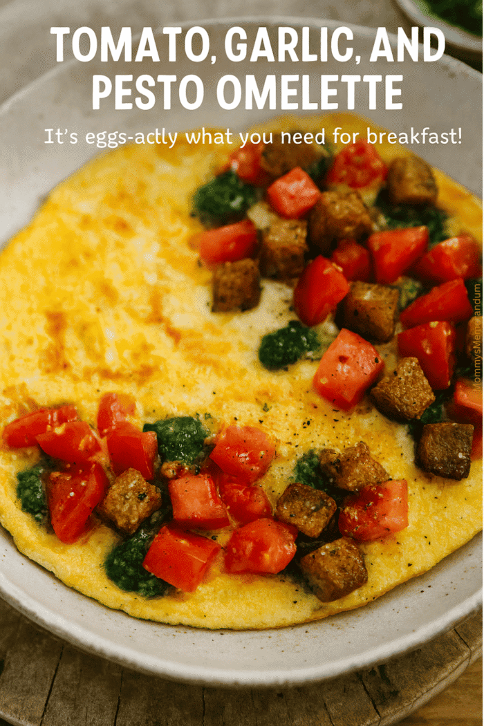 Tomato, Garlic & Pesto Omelette with Crispy Croutons Tomato, garlic, and pesto omelette with crispy whole-wheat croutons in a rustic ceramic skillet styled on a wooden table.