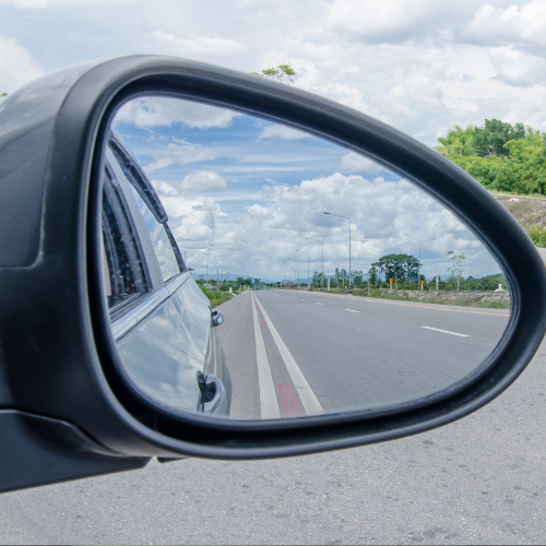 car mirror looking back on flat road