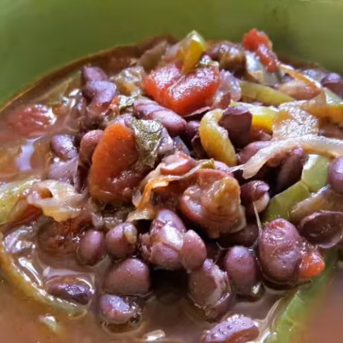 A bowl of rich and flavorful Instant Pot Cuban black beans with tomatoes, onions, and green peppers, ready to serve