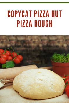 Fresh pizza dough ball surrounded by tomatoes and herbs, replicating Pizza Hut's dough recipe.