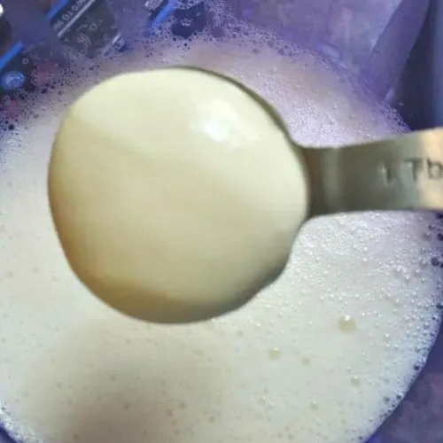 Yogurt starter being added to milk for making homemade Instant Pot yogurt