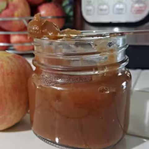 Homemade Instant Pot apple butter in a jar with a knife on top, ready to spread