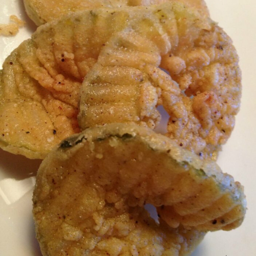 Crispy fried pickles with golden coating, served with a dipping sauce, showcasing the best fried pickles recipe.