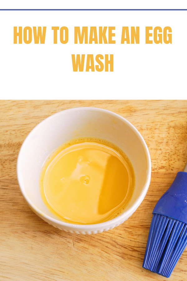 Egg wash in a white bowl next to a blue silicone pastry brush, perfect for achieving a golden finish.