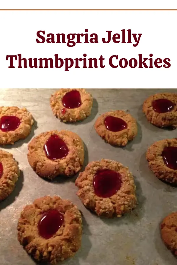 Peanut butter thumbprint cookies filled with sangria jelly, beautifully presented on a plate.