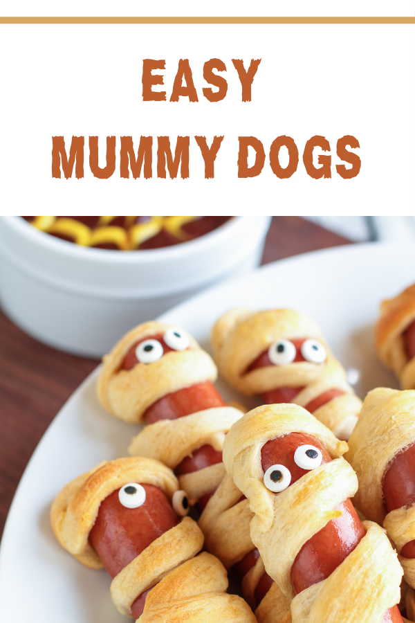 Spooky Halloween mummy dogs wrapped in crescent dough, topped with mustard eyes, perfect for kids and parties