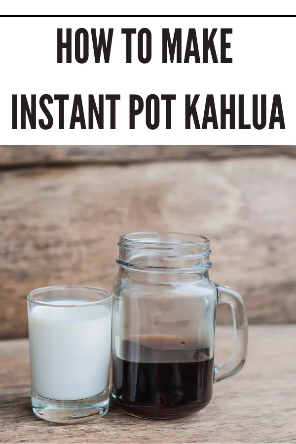 Mason jar filled with homemade Instant Pot Kahlua next to a cup of cream for coffee liqueur cocktails.