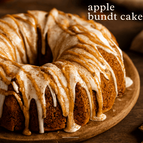 Golden brown apple Bundt cake drizzled with white glaze and cinnamon topping, styled on a rustic wooden table with warm lighting and fall decor.