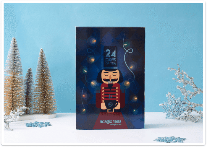 Nutcracker-themed Adagio Teas Tea Advent Calendar box with festive holiday decorations including miniature trees and glittery snowflakes.